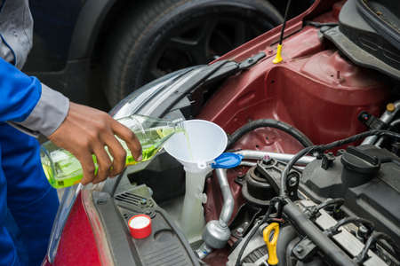 Close-up Of Mechanic Pouring Oil Into The Car Engine