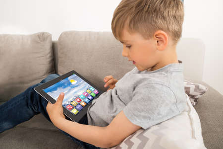 Boy Using Digital Tablet With Multicolored Apps On It