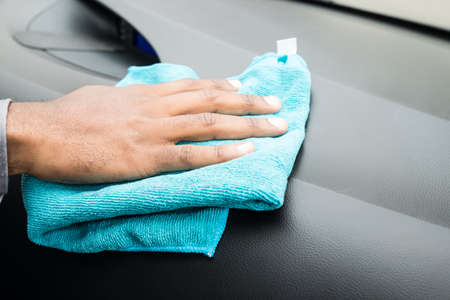 Close-up Of Person Hands Cleaning Car Interior With Blue Cloth