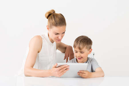Smiling Mother And Son Using Digital Tablet At Homeの写真素材