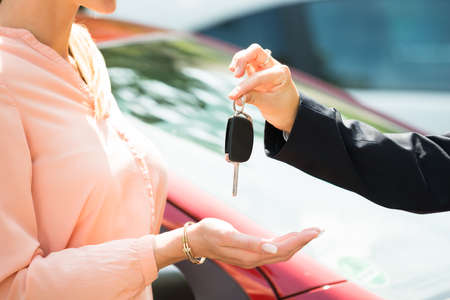 Close-up Of A Dealer Giving Car Key To Womanの写真素材