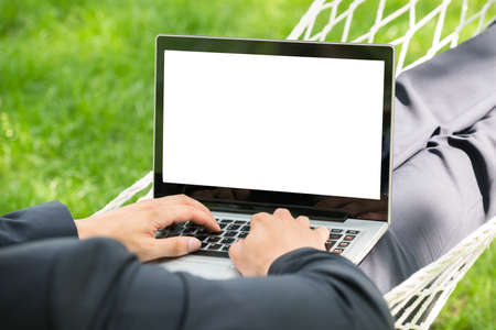 Close-up Of Person In Hammock With Laptop Showing Blank Screenの写真素材