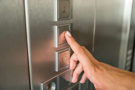 Close-up Of Female's Hand Pressing First Floor Button In Elevator
