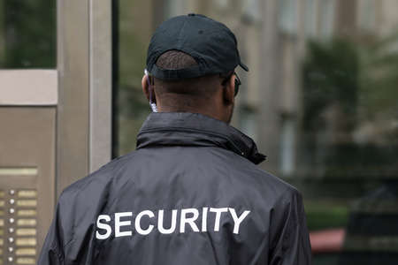Rear View Of A Male Security Guard Wearing Black Uniformの写真素材