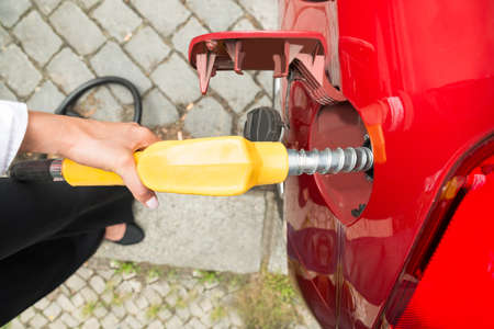 Close-up Of Businesswoman's Hand Refueling Her Carの写真素材