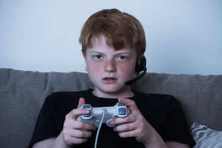 Portrait Of Boy With A Joystick Playing Videogames At Home