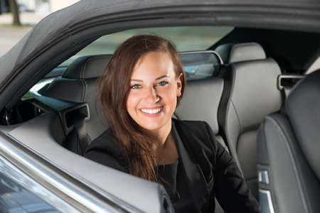 Portrait Of A Young Happy Businesswoman Sitting Inside The Carの写真素材