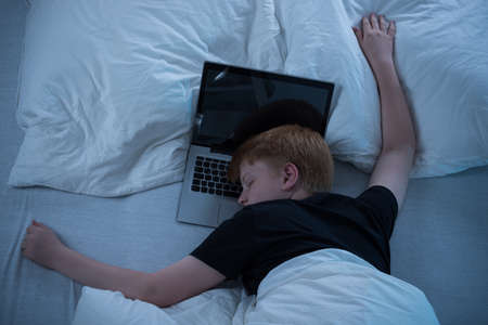 Child Sleeping On Bed With His Laptop