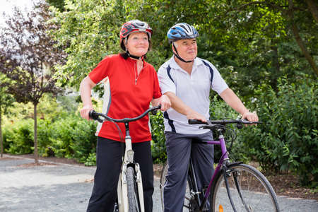 Portrait Of Happy Elderly Couple With Their Bicyclesの写真素材