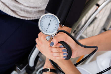 Close-up Of A Doctor Checking Blood Pressure Of Patient In Clinicの写真素材