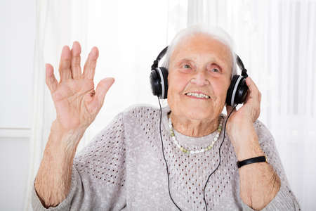 Portrait Of Happy Senior Woman Enjoying Music With Headphone At Home