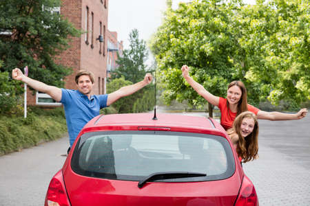 Excited Happy Family Looking Out Of A Car In City