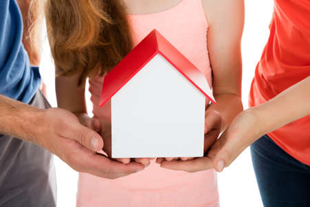 Close-up Of A Family Holding House Modelの写真素材