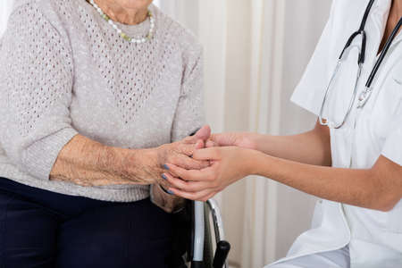 Close-up Of Female Doctor Consoling Handicapped Senior Patient In Hospitalの写真素材
