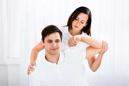 Masseur Giving Massage To Young Man In Spa