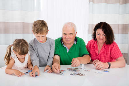 Family Holding Jigsaw Puzzle Pieces While Playing Game
