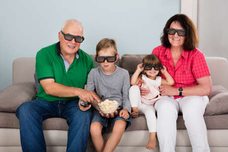 Family Entertaining Watching 3D TV At Home With Kids