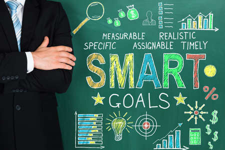 Close-up Of Successful Businessperson Standing Near Blackboard Showing Smart Goal Conceptの写真素材