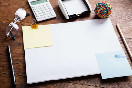 High Angle View Of Colourful Paper Note Attached On Notebook With Paper Clips For Reminder On Wooden...