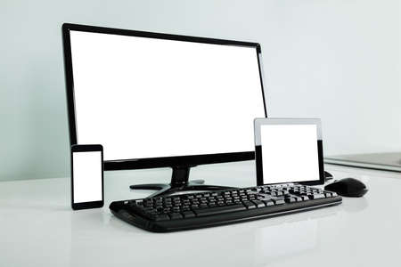 Computer Desktop With Digital Tablet And Mobilephone Showing Blank Screen On Office Desk