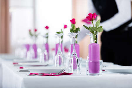 Male Waiter Placing Napkin On Wedding Table