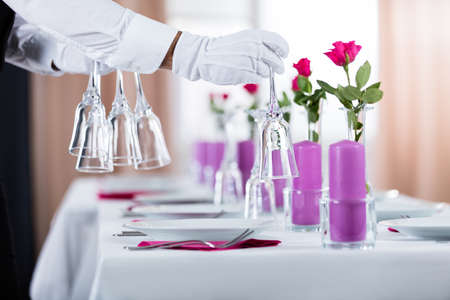 Close-up Of Waiter Setting Wedding Table At Restaurant