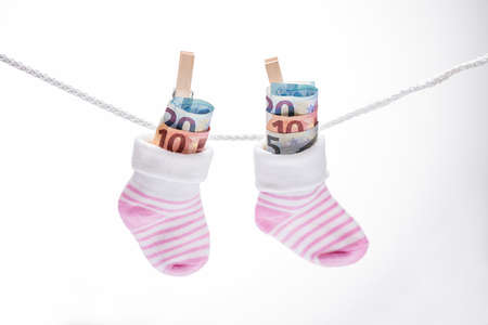 Pair Of Baby Sock With Dollar Hanging On Rope Using Wooden Clip