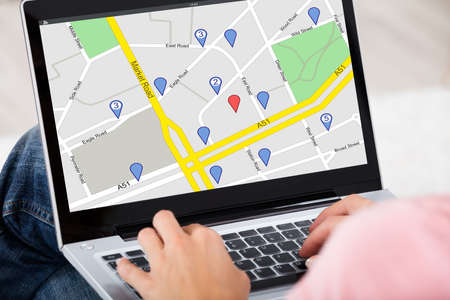 Close-up Of A Woman Using GPS Map With Navigation Pointers On Laptop At Home