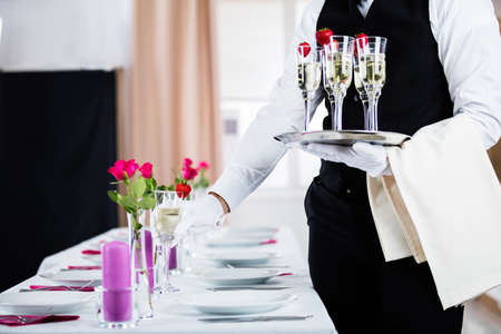 Waiter Serving Champagne On Banquet Table At Restaurant