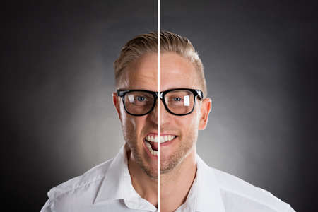 Man's Face Showing Anger And Happy Emotions Against Black Backgroundの写真素材