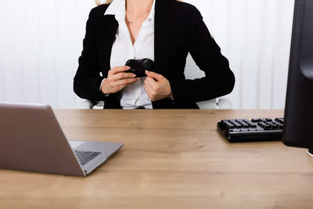 Close-up Of A Businesswoman Stealing Computer Mouse At Office Deskの写真素材