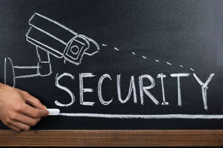 Close-up Of A Person Hand Showing Security Concept On Blackboardの写真素材
