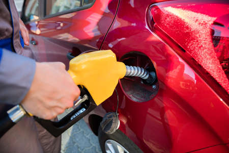 Person's Hand Refueling Car's Tank By Holding Petrol Pump Nozzleの写真素材
