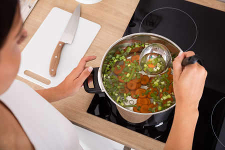High Angle View Of Woman Preparing Soup In Kitchenの写真素材