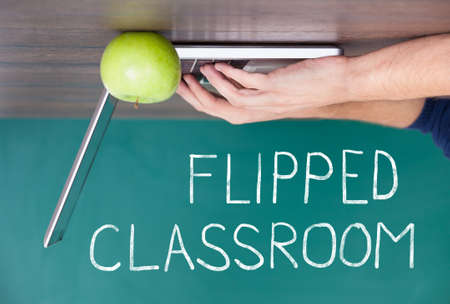 Flipped Classroom Concept On Blackboard With Person Using Laptopの写真素材