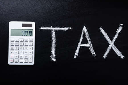 Tax Concept With Calculator On Black Blackboardの写真素材