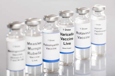 Syringe And Vaccine Bottles With Different Labels In A Row