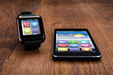Mobile Phone With Smart Watch Showing Different Application On Wooden Floorの写真素材