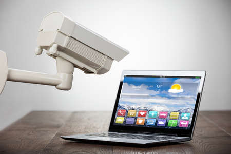 Security Camera On Laptop At Wooden Desk Showing Different Application