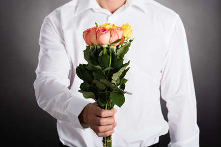 Close-up Of A Man Giving Bunch Of Roses As Presentの写真素材