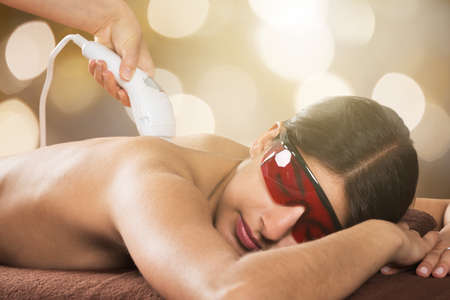 Woman With Protective Glasses Receiving Laser IPL Treatment At Beauty Spaの写真素材