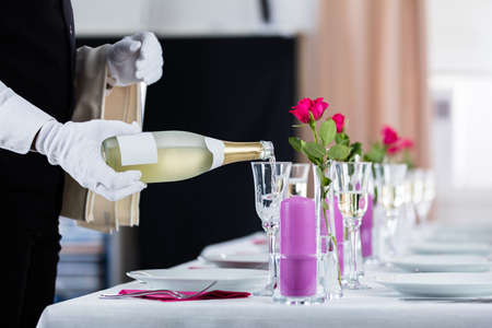 Close-up Of Waiter Pouring Champagne Into Glassの写真素材