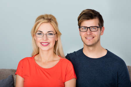 Portrait Of Young Smiling Couple Wearing Glassesの写真素材