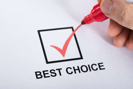 Close-up Of A Person Hand Ticking Best Choice In Check Box Option Using Red Marker