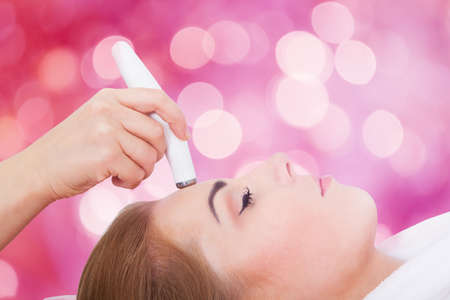 Close-up Of A Young Woman Receiving Microdermabrasion Therapy On Forehead