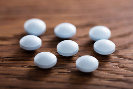 Close-up Of Ecstasy Pills On Wooden Desk