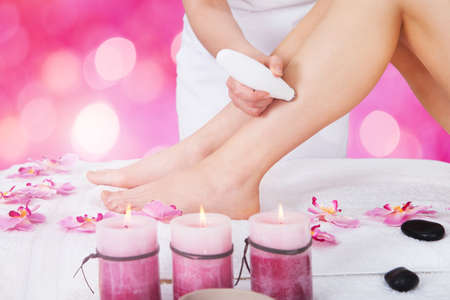 Close-up Of A Beautician Using Laser Machine On Customer's Leg At Beauty Spa