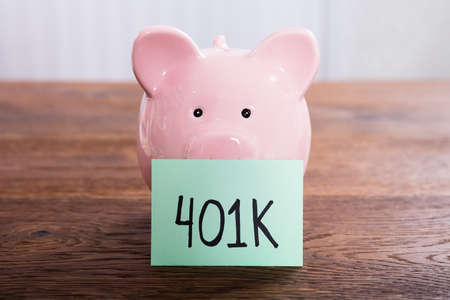 Close-up Of A Piggy Bank For 401k Savings At Wooden Deskの写真素材