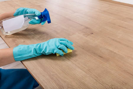 Woman Wearing Gloves Cleaning Kitchen Worktop At Homeの写真素材