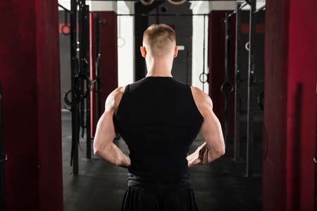 Rear View Of An Athlete Man Standing In The Gym